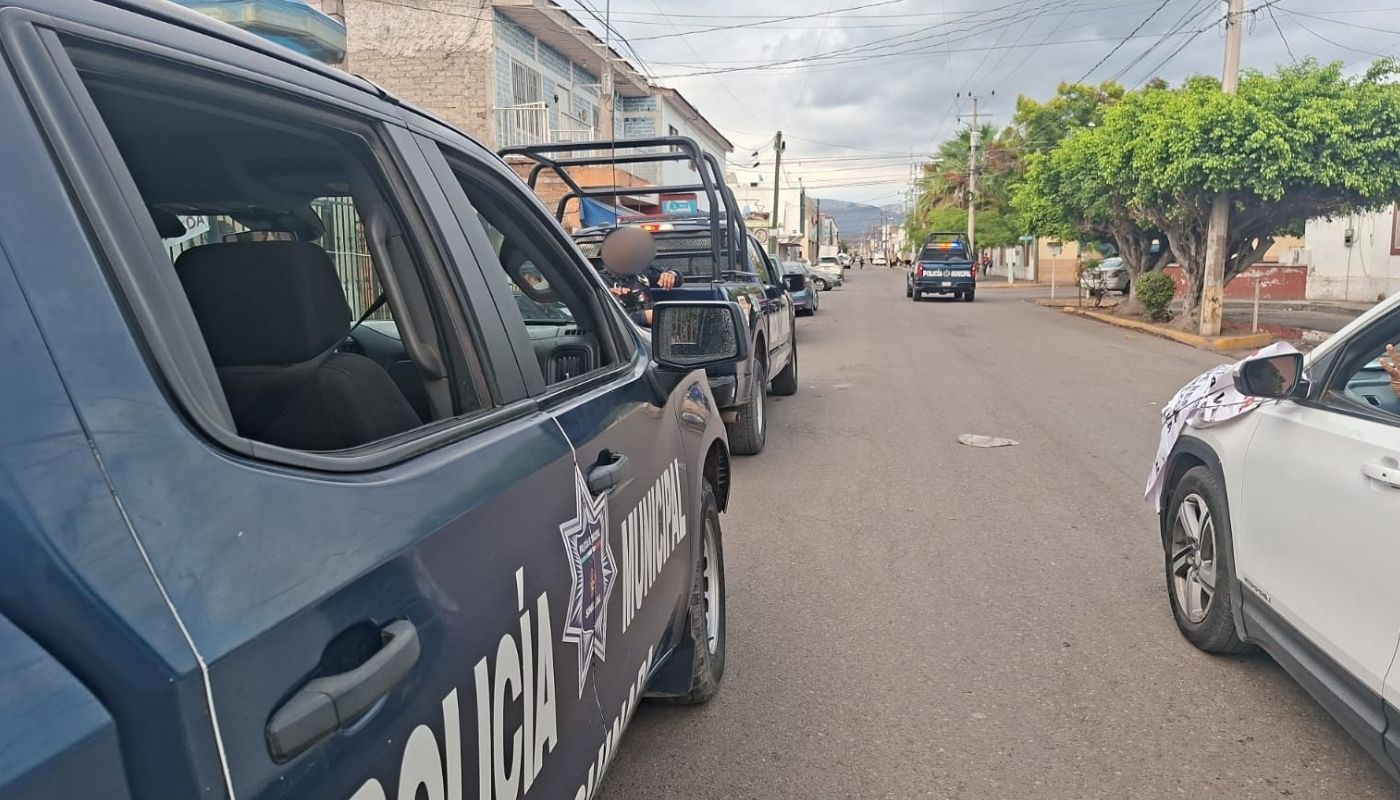 Camioneta de la policía municipal junto a un carro color blanco