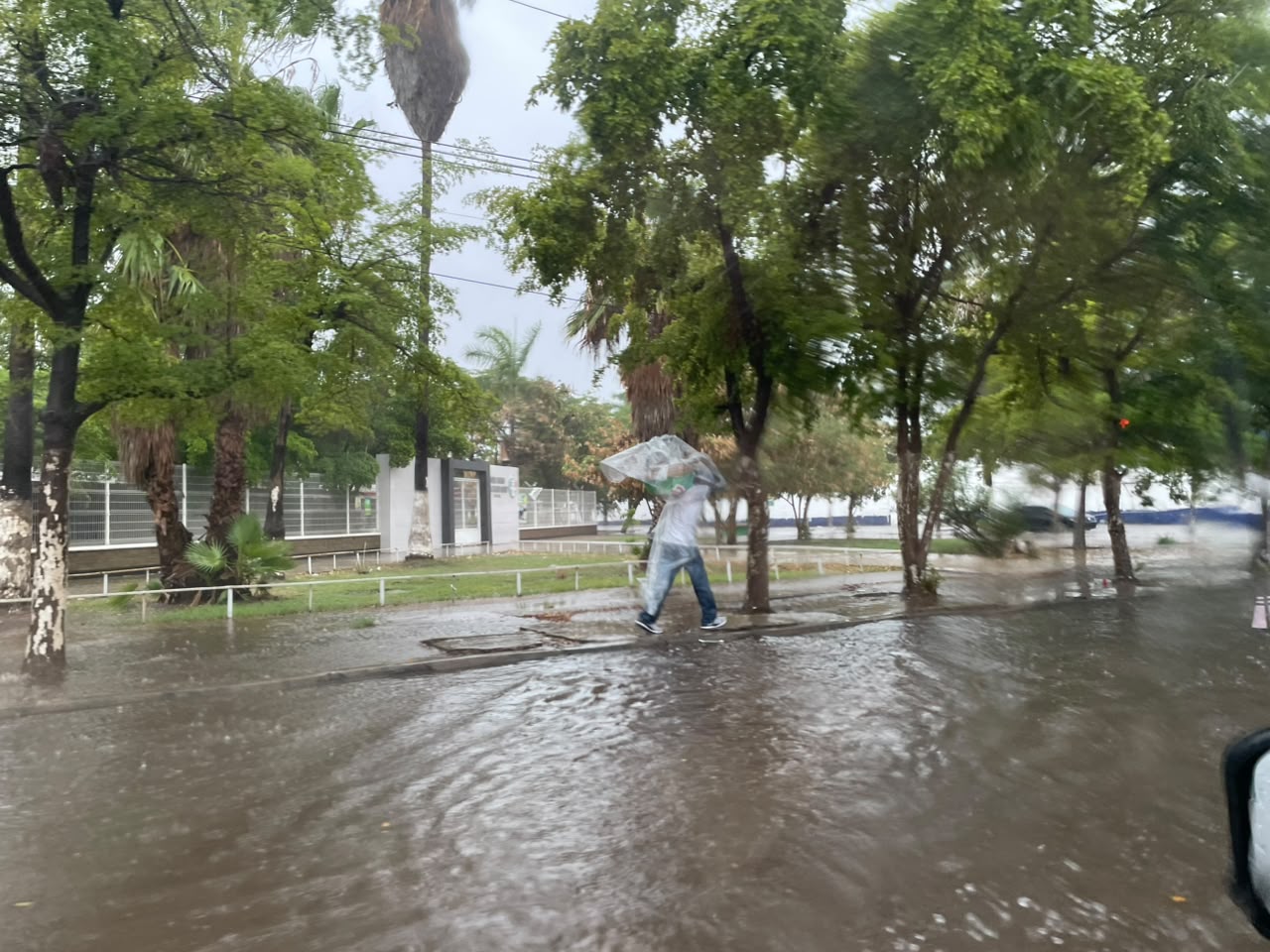 Calle inundada con una persona con plástico