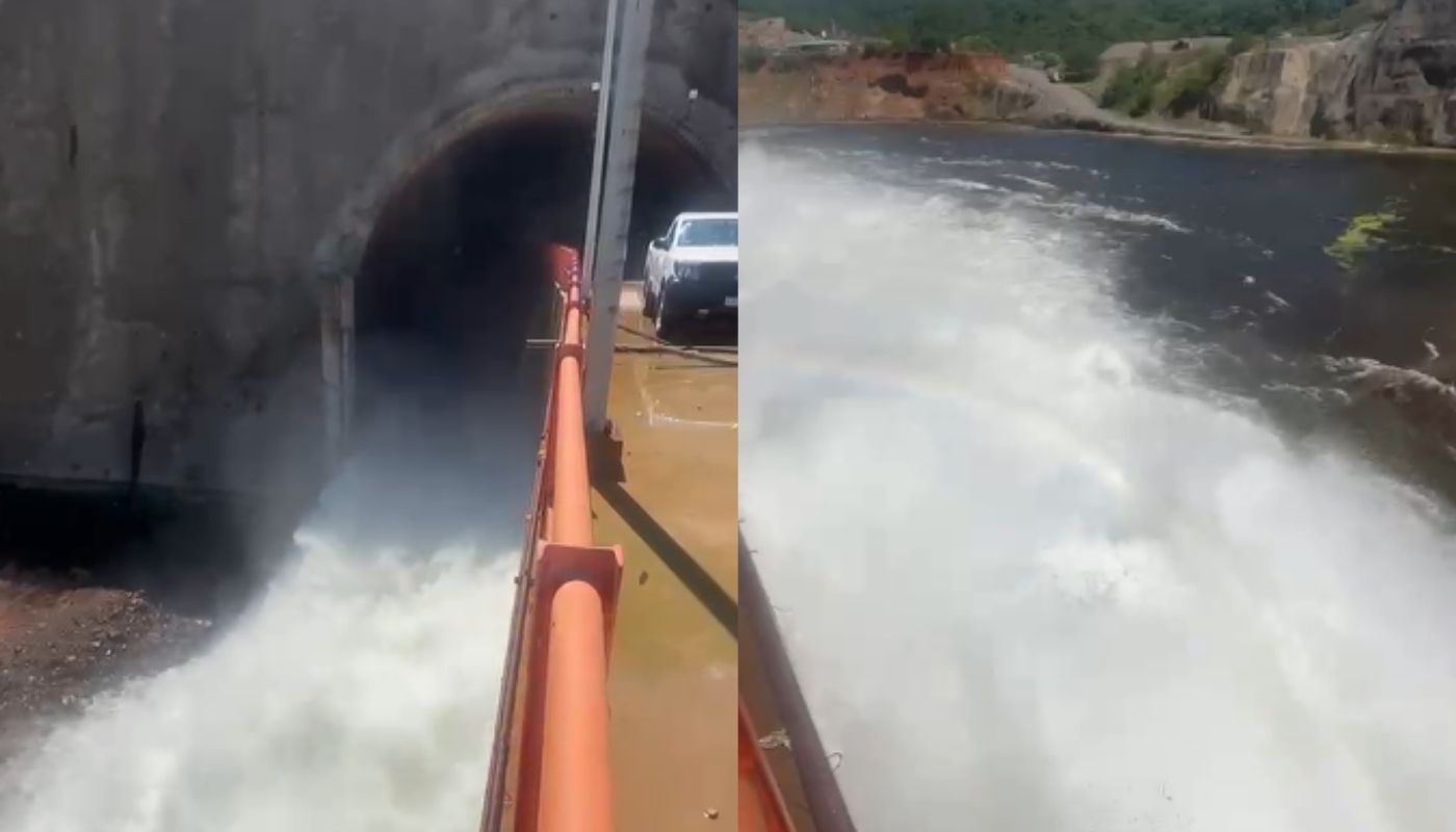 Desfogue de agua en presa junto a carros