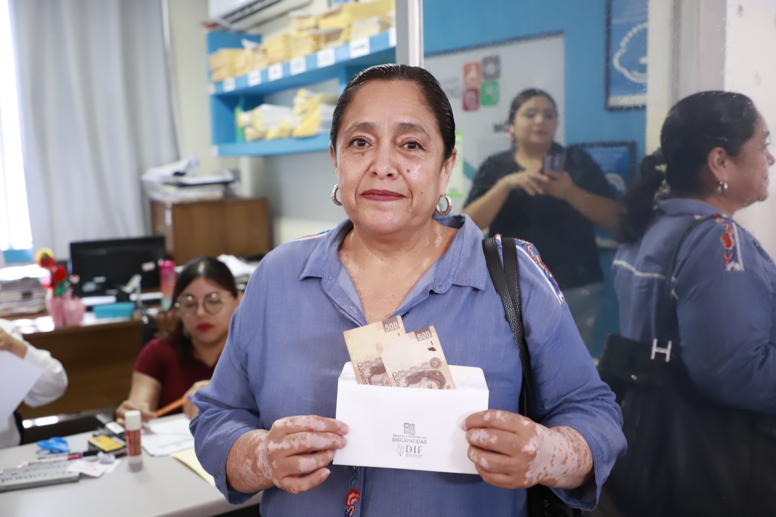 Ciudadana recibiendo su apoyo económico por parte del Sistema DIF Mazatlán.