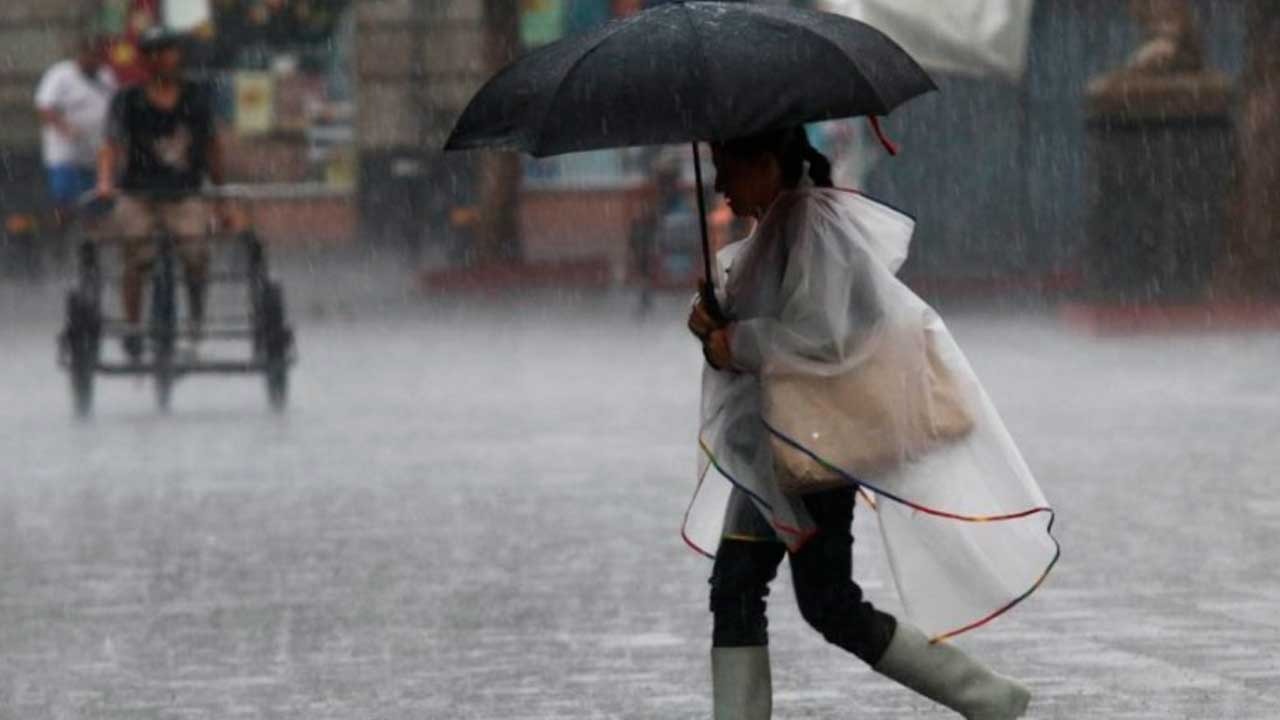 Mujer en la lluvia con paraguas e impermeable