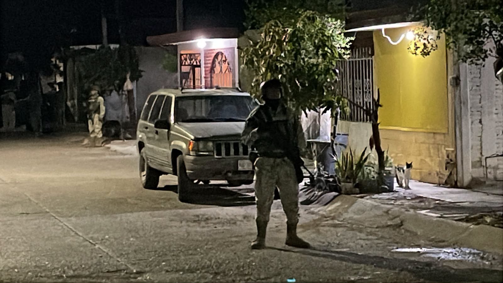Elemento militar en una calle entre casas de noche