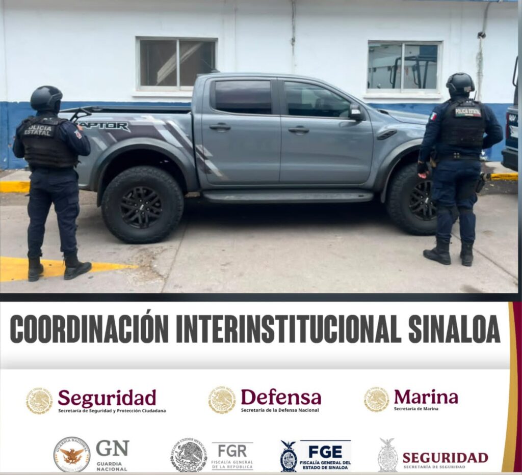 Personal policiaco de espaldas y al fondo una camioneta de color gris