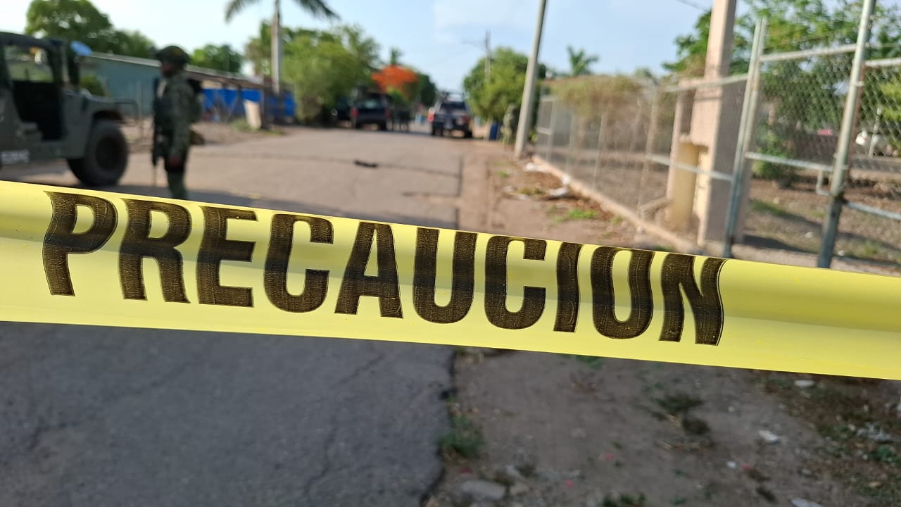 cinta de precaución en una calle con carros y elementos de diferentes corporaciones policiacas desplegados en la zona