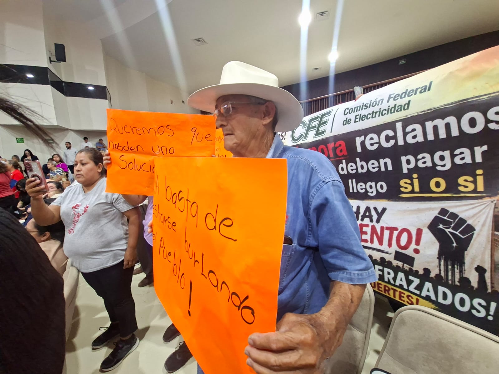 Señor con sombrero y una cartulina color naranja