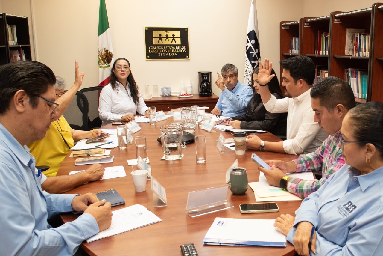 Titular de la CEDH junto a personal en una mesa