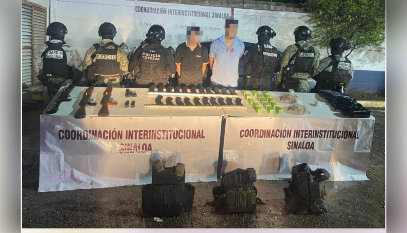 civiles detenidos con le rostro cubierto y las manos esposadas junto a elementos policiacos, al frente una mesa con armas y objetos asegurados