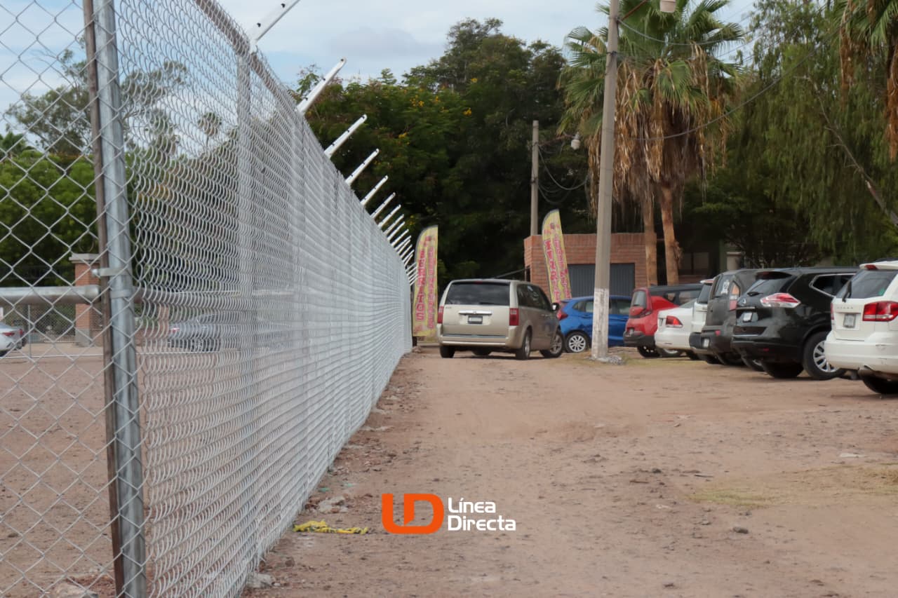 carros en un estacionamiento y un cerco