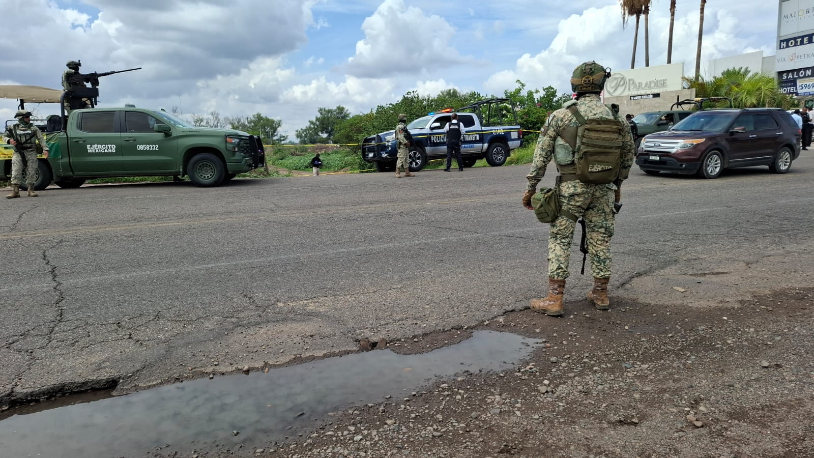 Soldado y al fondo patrullas del Ejercito y de la policia delimitan un área