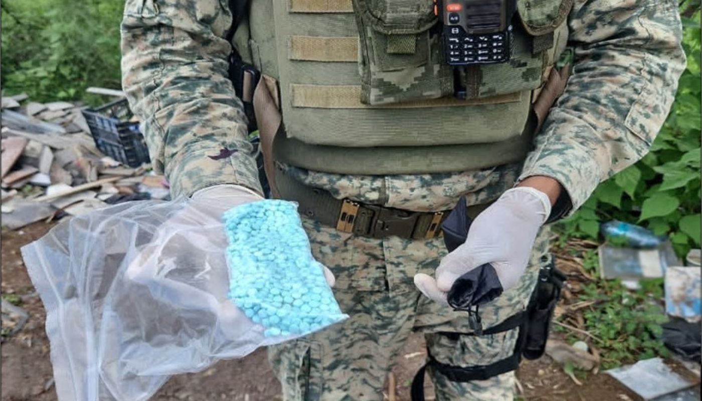 Militar sosteniendo una bolsa transparente con pastillas azules