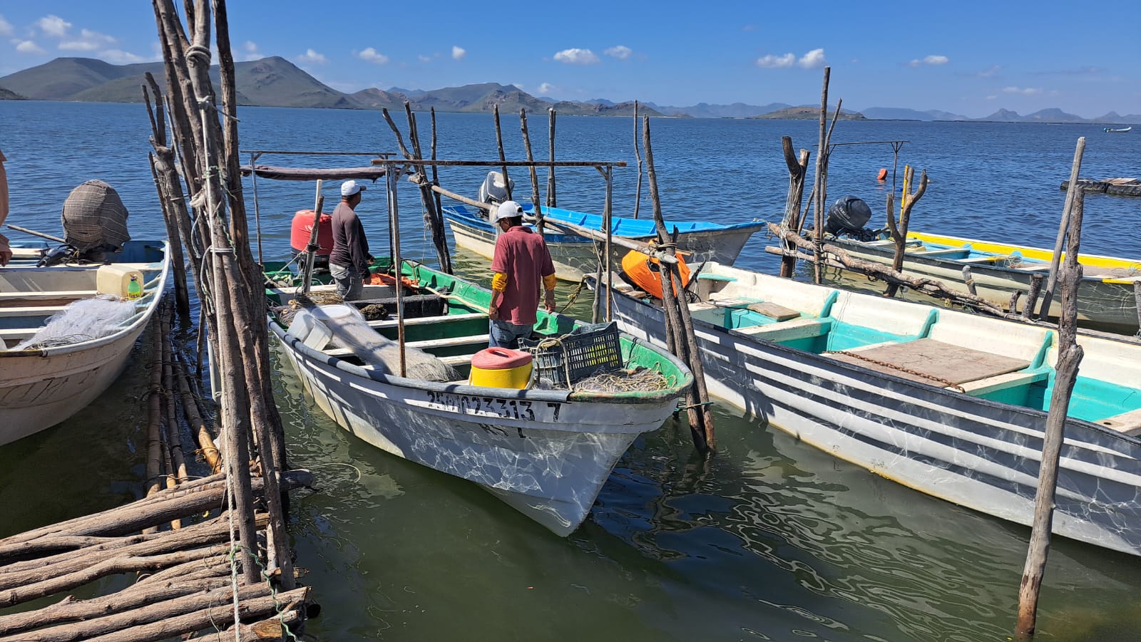 pescadores en embarcaciones paradas en un muelle en el mar