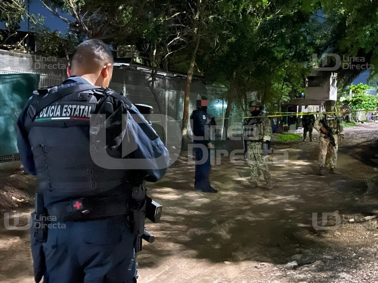 Elementos policiacos en un camino de terracería con cinta amarilla de precaución