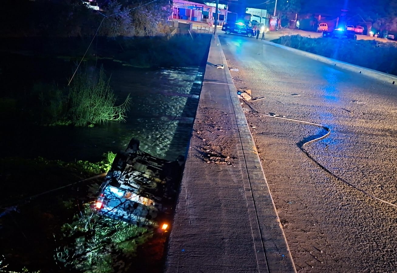 carro volcado en un río junto a un puente/calle